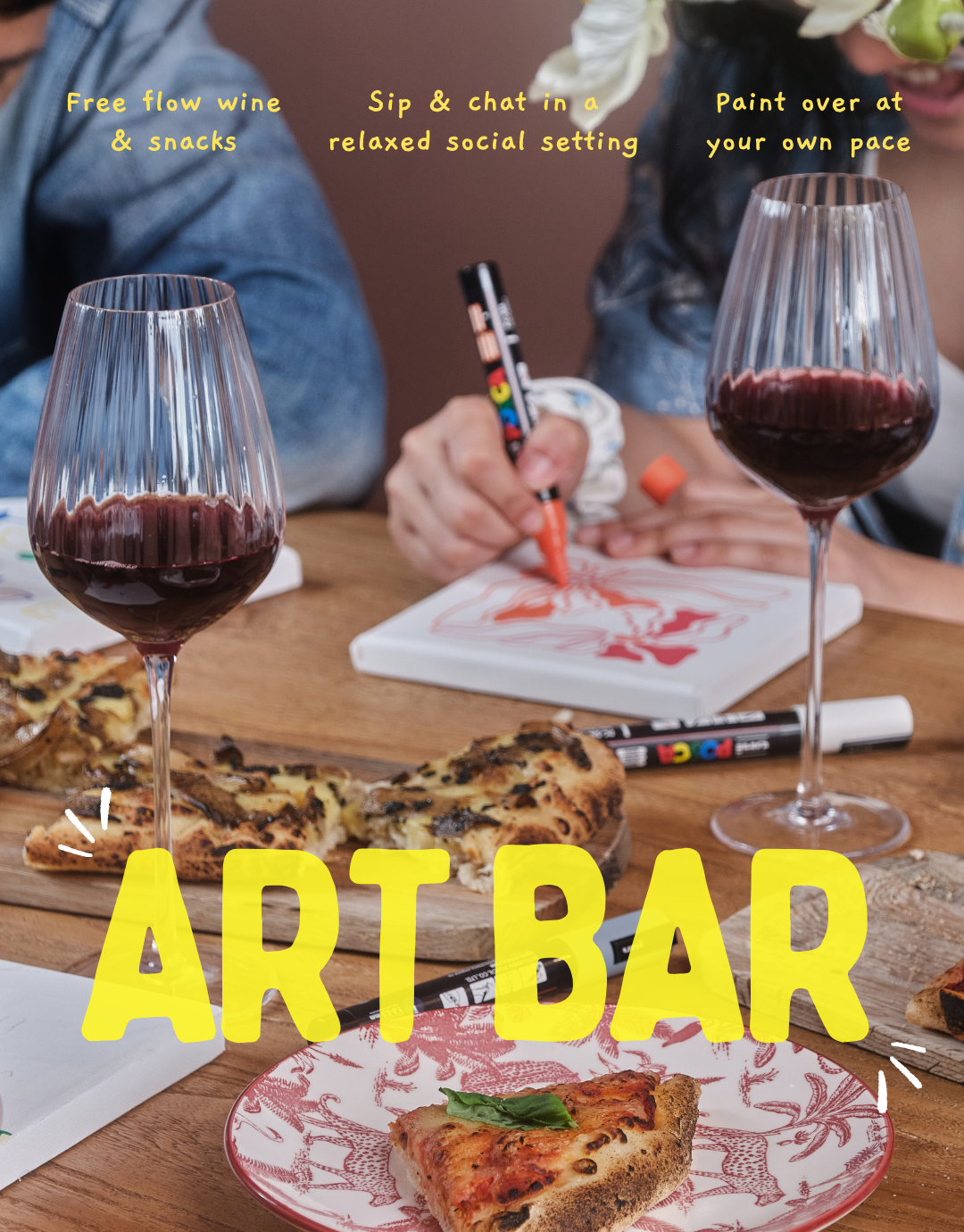 Art Bar setup with wine glasses, pizza, and people painting.