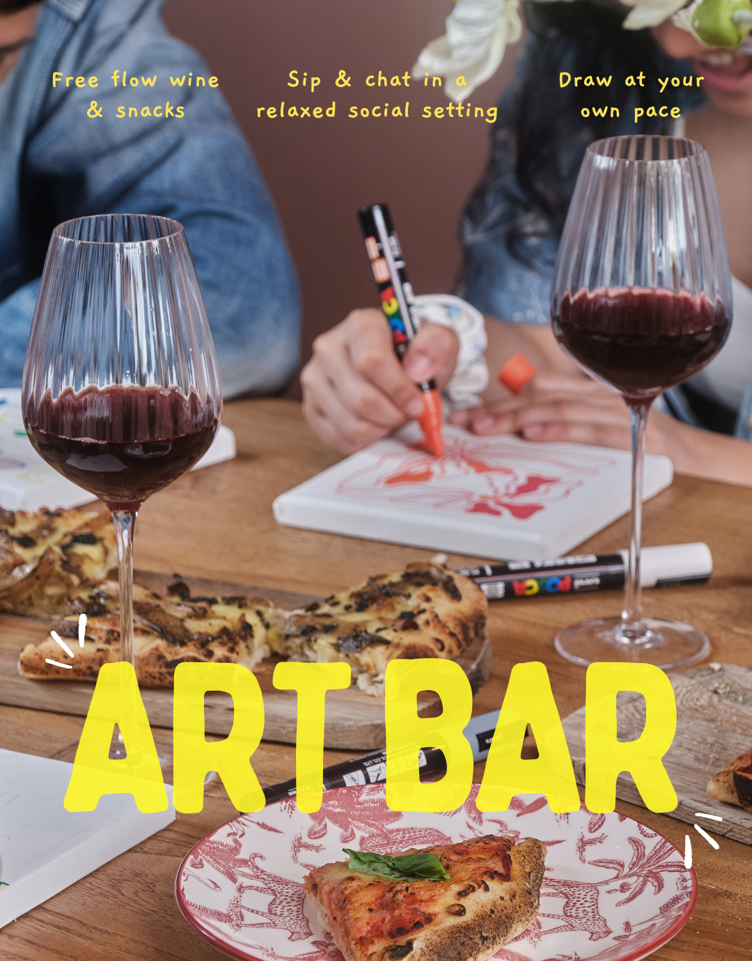 Art Bar setup with wine glasses, pizza, and people painting.